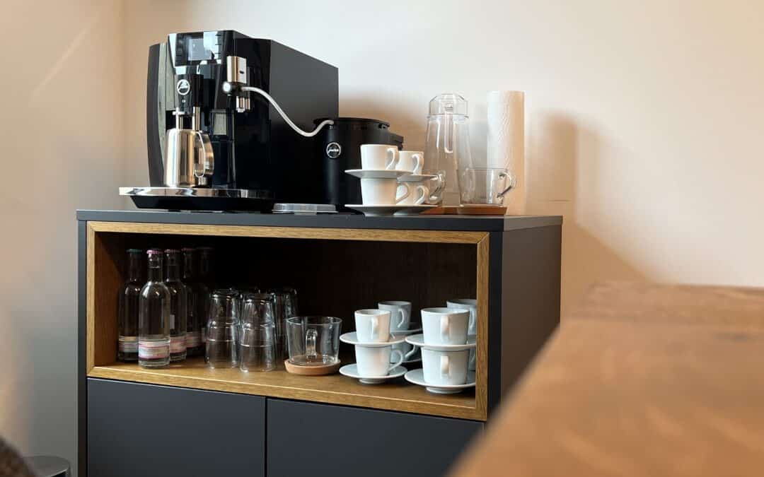 Einladender Besprechungstisch aus Eiche mit passender Kaffeebar