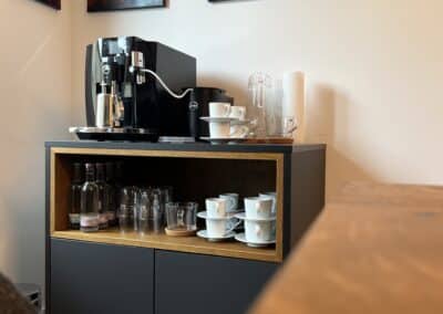 Einladender Besprechungstisch aus Eiche mit passender Kaffeebar